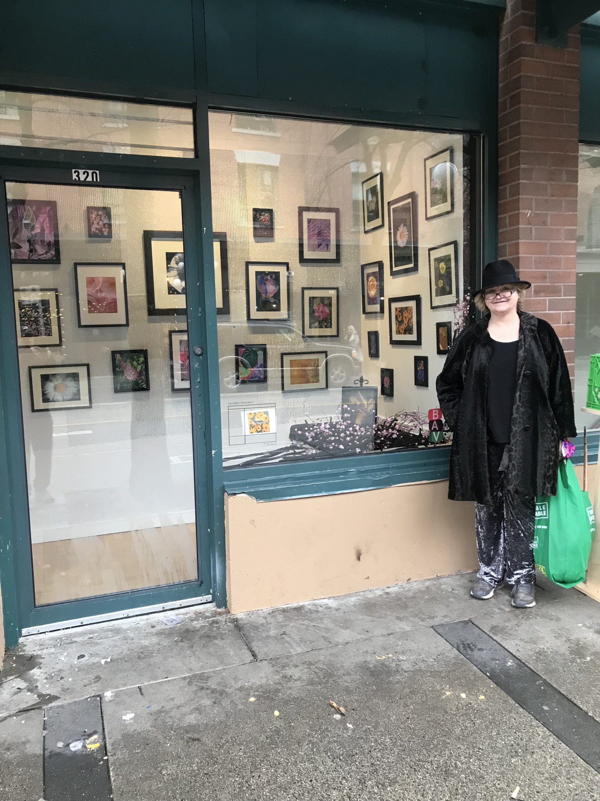 Melanie standing outside of the Cheeky Proletariat at her art show.